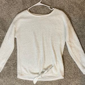 White sweater with tie detail on front.